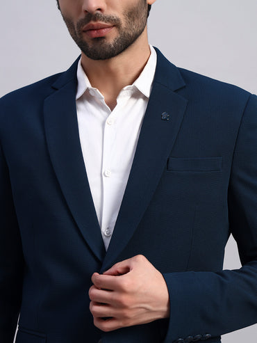 Close view of stretch fabric in peacock green blazer